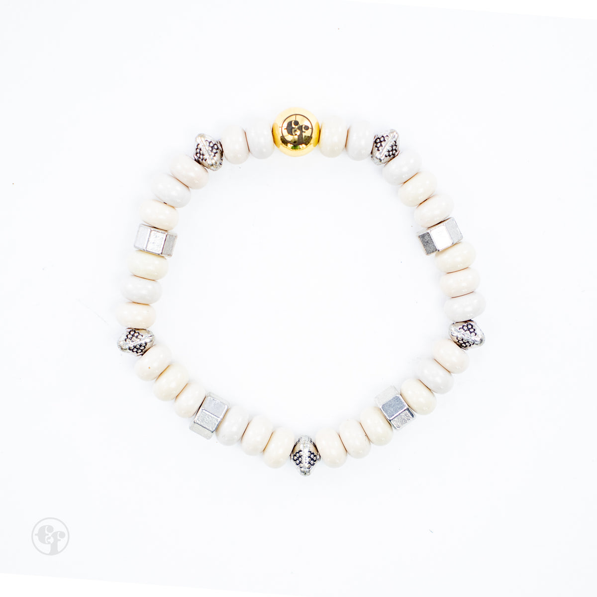 Top-down view of cream rondelle beads with silver-tone hexagonal and dotted accents and a polished gold-tone emblem bead.