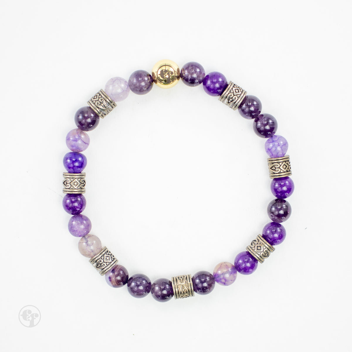 Top view of an amethyst bead bracelet with patterned silver-tone spacers and a gold-tone emblem bead.